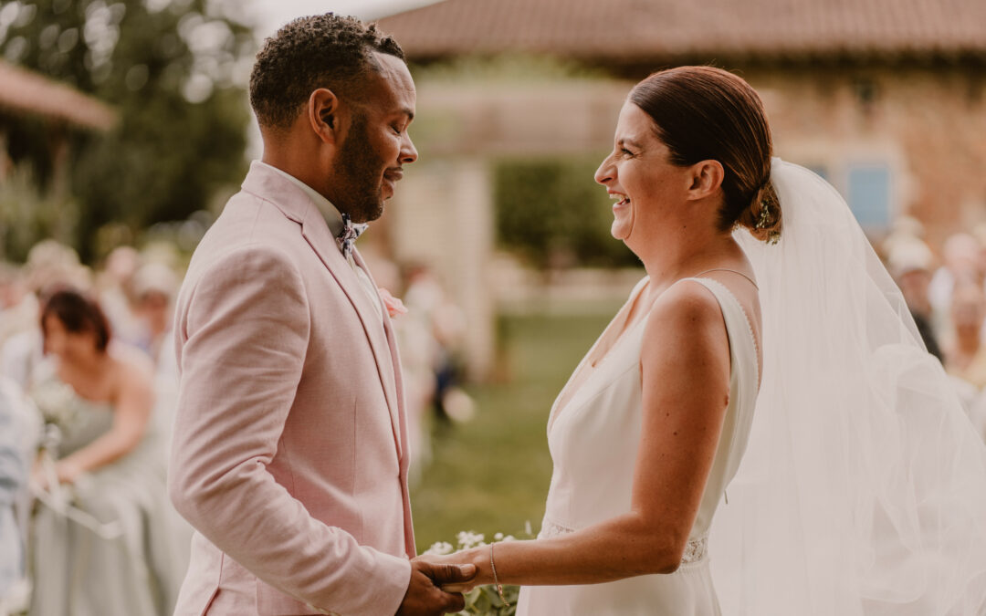 Mariés échangeant un regard complice pendant leur cérémonie laïque avec un officiant professionnel